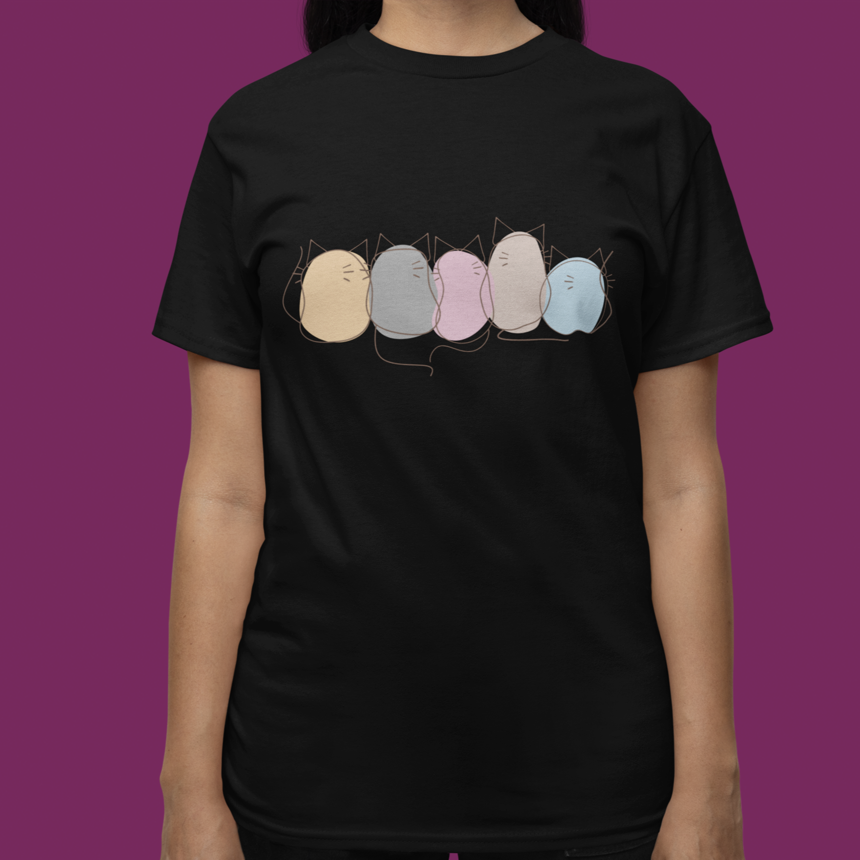 Person wearing a black t-shirt with colorful graphic design on a purple background