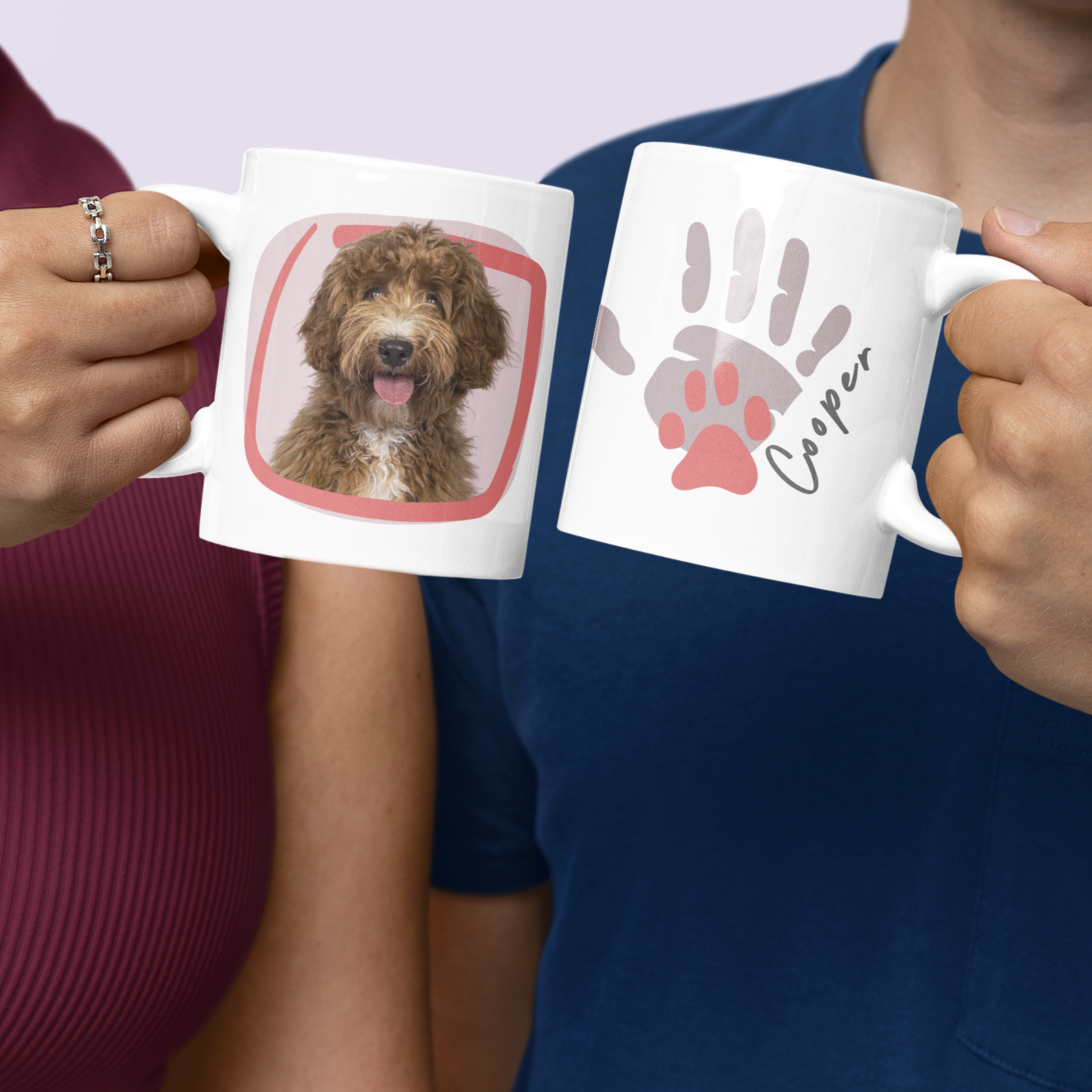 Two people holding mugs with printed designs of a dog and handprints.