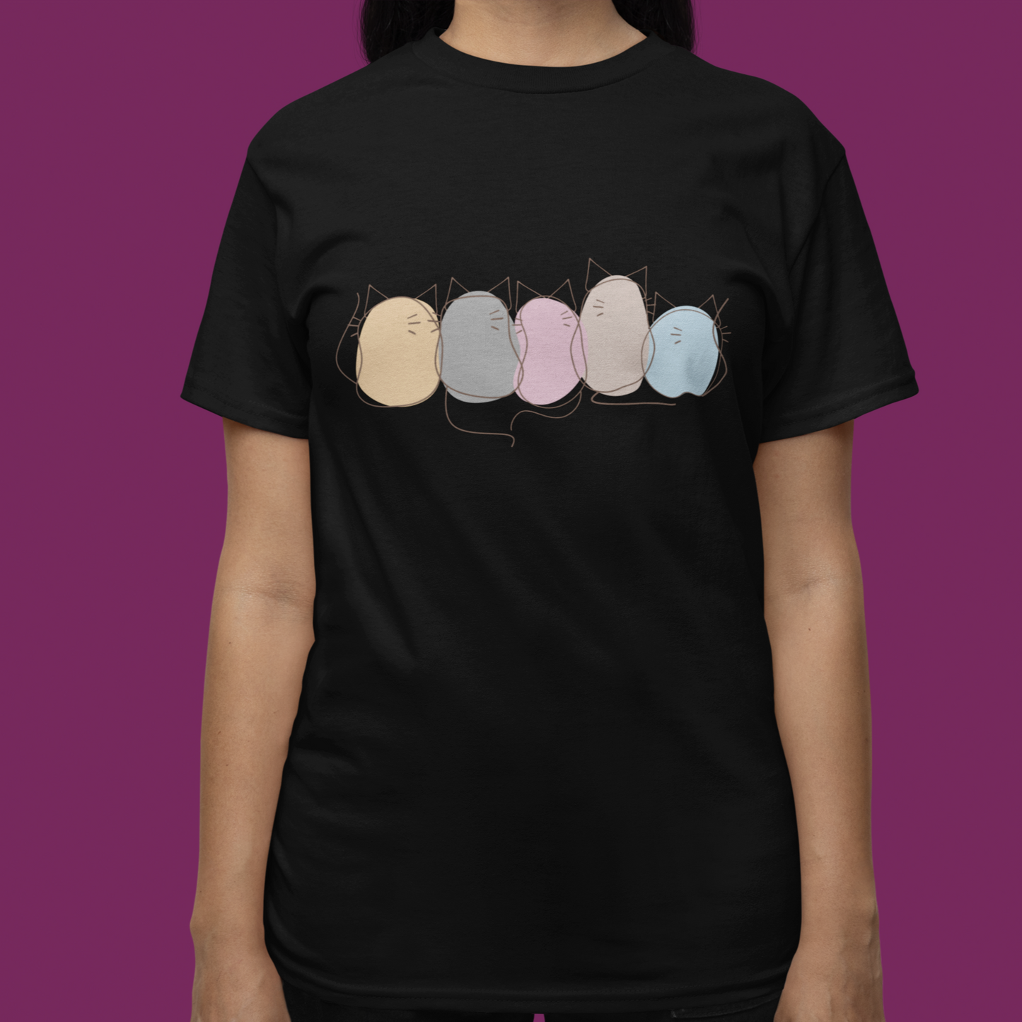 Person wearing a black t-shirt with colorful graphic design on a purple background